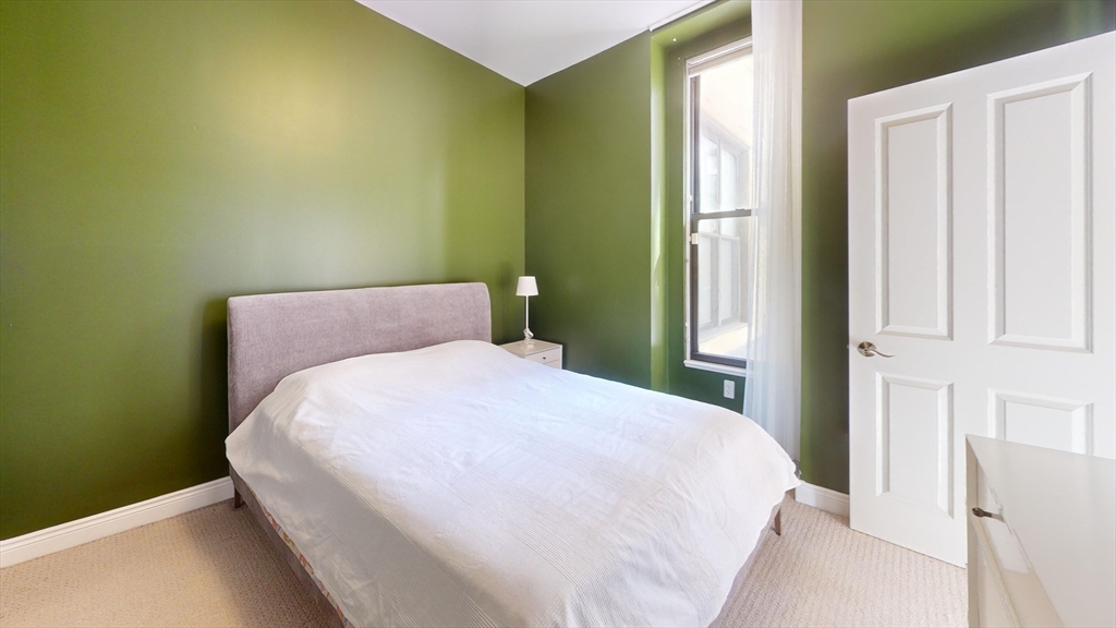 4 Charlesgate East, Unit 107 Boston, MA 02215 - Photo 4 of 23 a bed sitting in a bedroom next to a window
