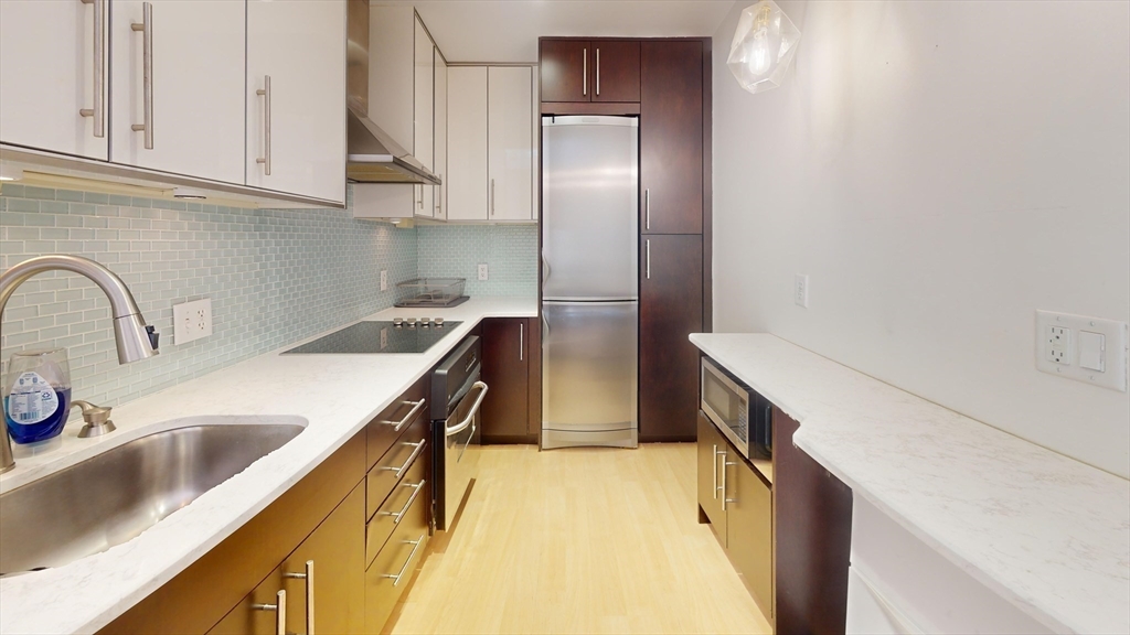 4 Charlesgate East, Unit 107 Boston, MA 02215 - Photo 6 of 23 a kitchen with stainless steel appliances granite countertop a sink and a refrigerator