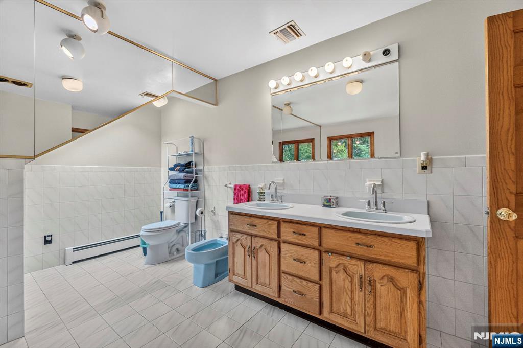 5110 Berkshire Valley Road Oak Ridge, NJ 07438 - Photo 34 of 49 a bathroom with a double vanity sink mirror and toilet
