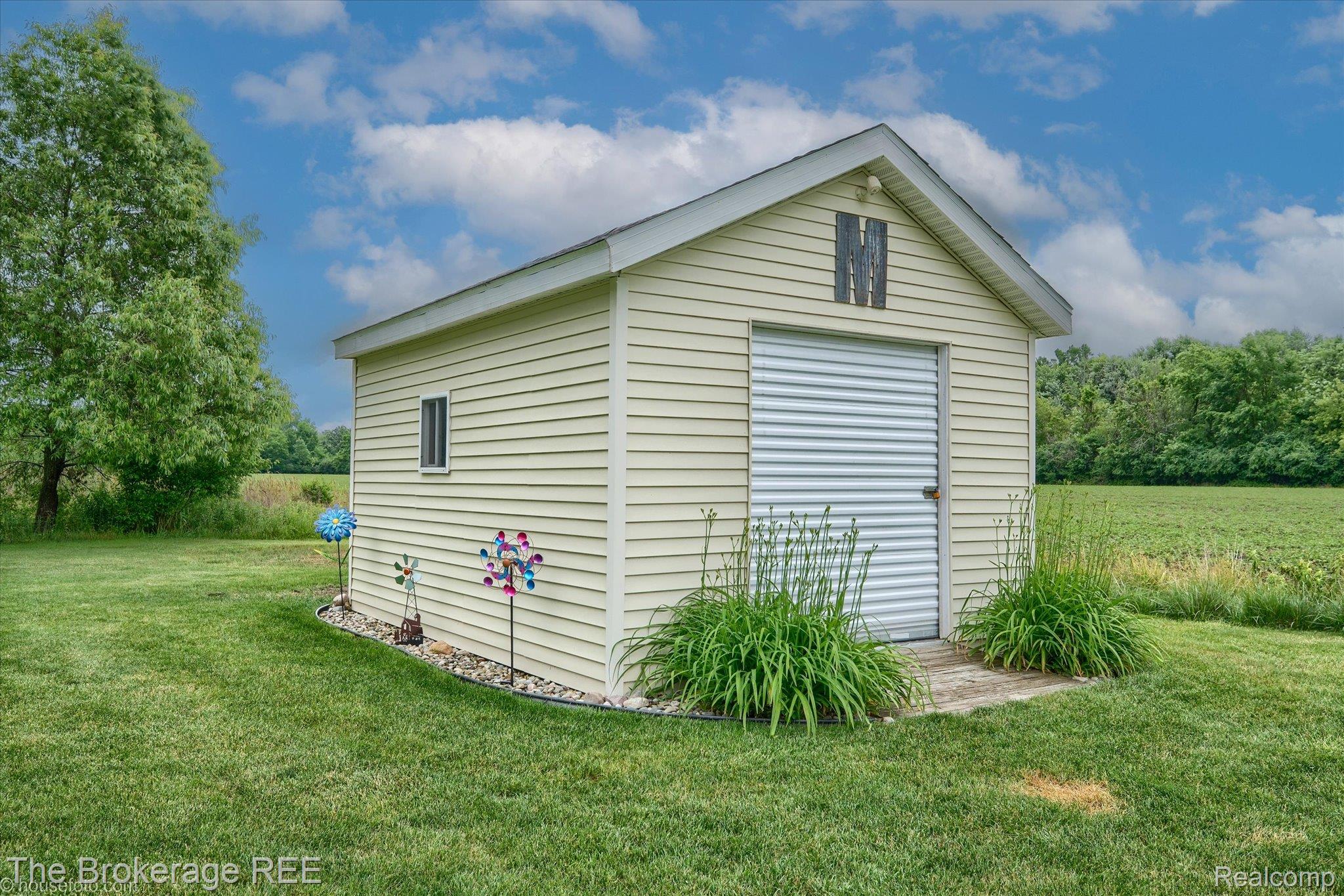 4432 North Belsay Road Flint, MI 48506 - Photo 8 of 79 Detached outbuilding with light-colored siding, a roll-up door, and a single window