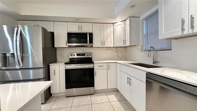 a kitchen with a sink stove and refrigerator