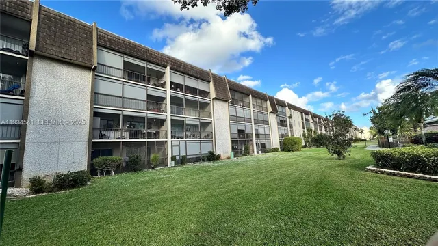 a view of a large building with a big yard and large trees
