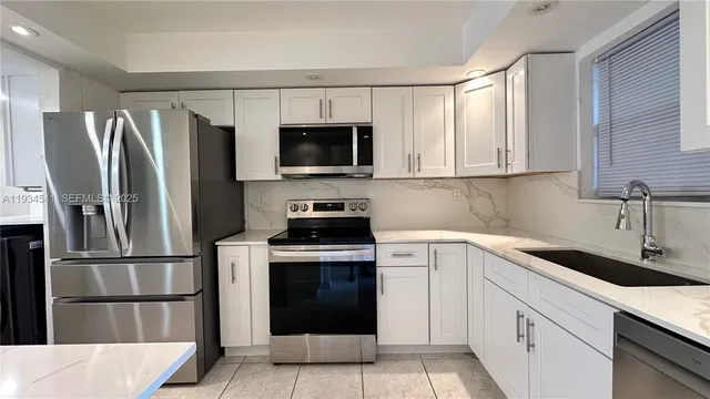 a kitchen with stainless steel appliances a refrigerator sink and microwave