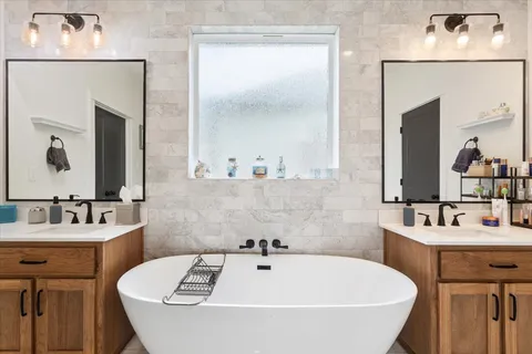 a bathroom with a tub sink and mirror