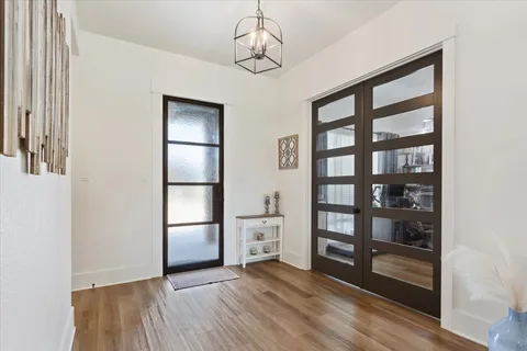 an empty room with wooden floor closet and windows