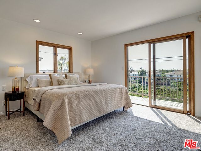 a spacious bedroom with a bed and a large window