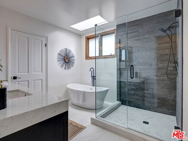 a bathroom with a bathtub shower sink and mirror