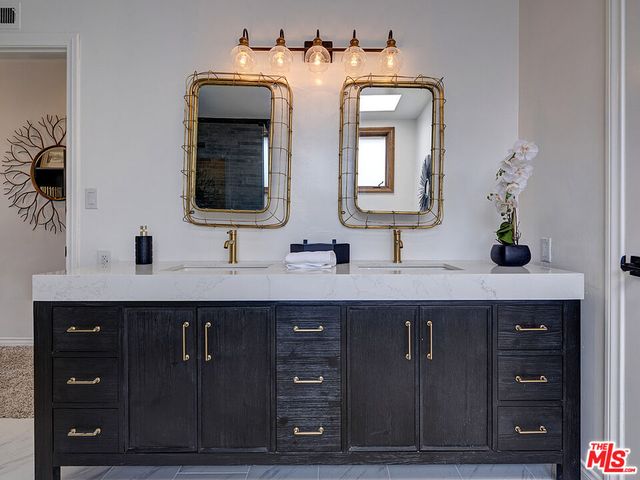 a bathroom with a double vanity sink and mirror