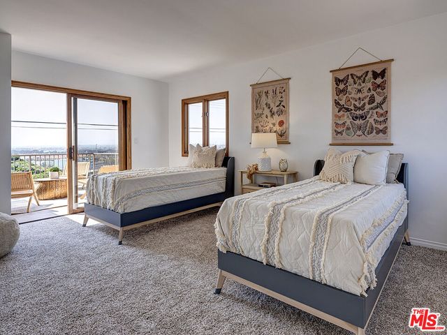 a spacious bedroom with a bed and glass window