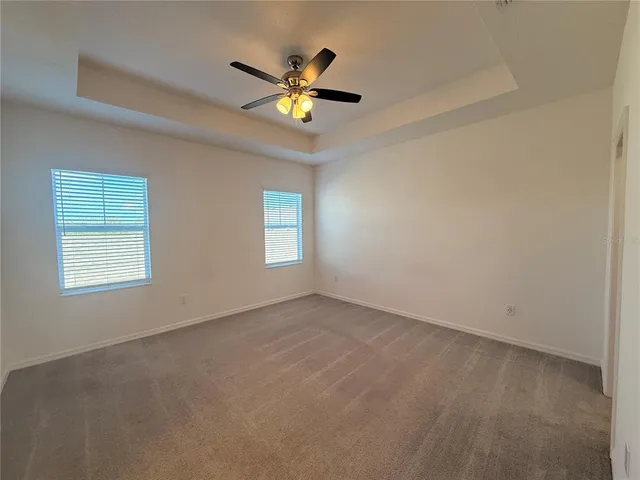 an empty room with a ceiling fan and a window
