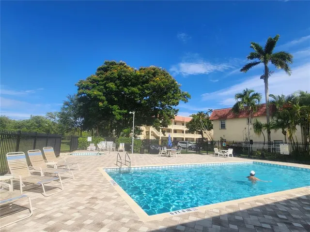 a view of a swimming pool with a patio and a yard