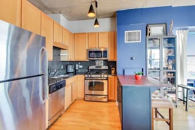 a kitchen with stainless steel appliances granite countertop a refrigerator stove top oven a sink and dishwasher
