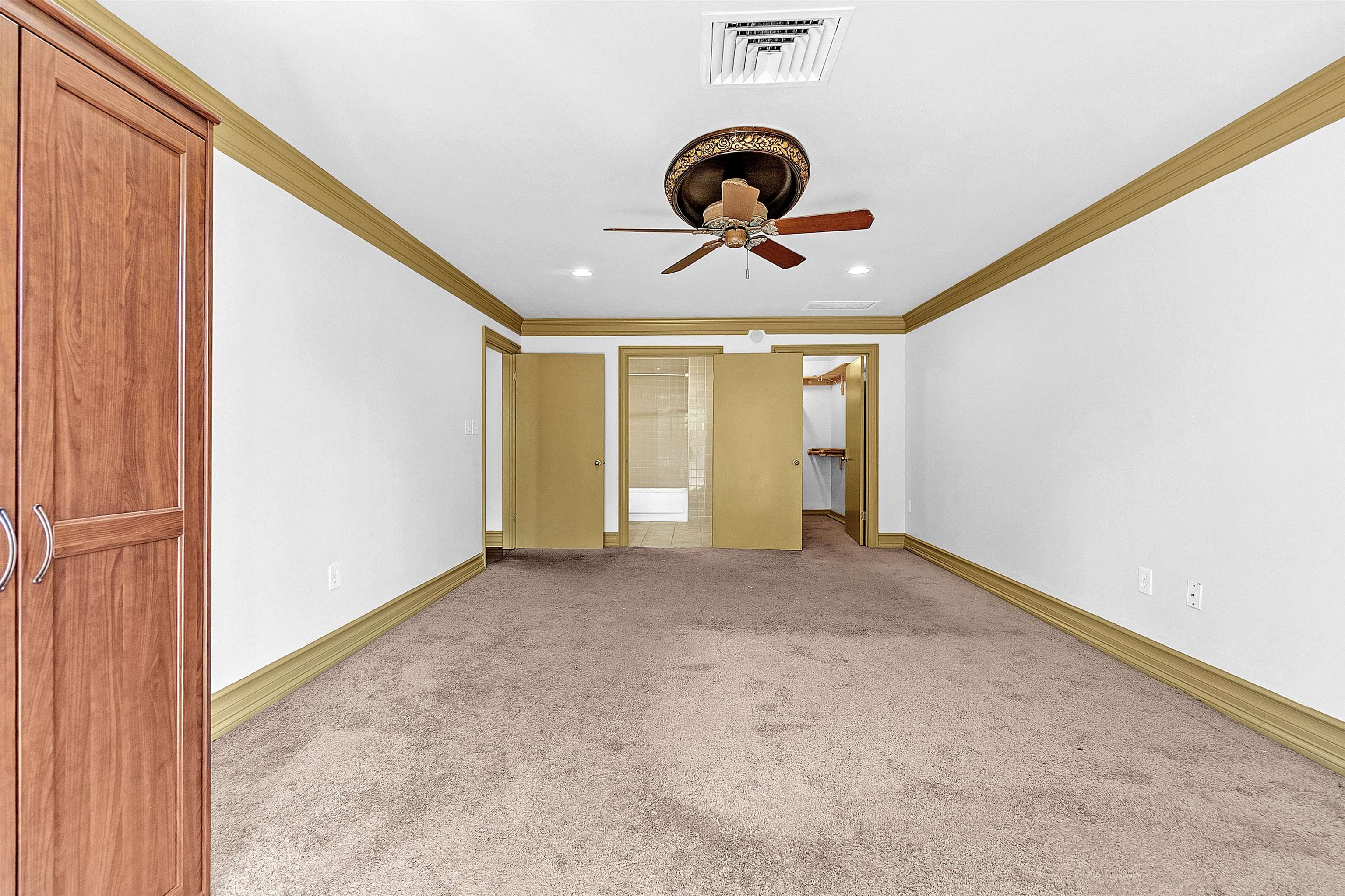655 Riverside Drive, Unit 206 Memphis, TN 38103 - Photo 23 of 28 Unfurnished bedroom with ensuite bath, light carpet, ornamental molding, recessed lighting, and a ceiling fan