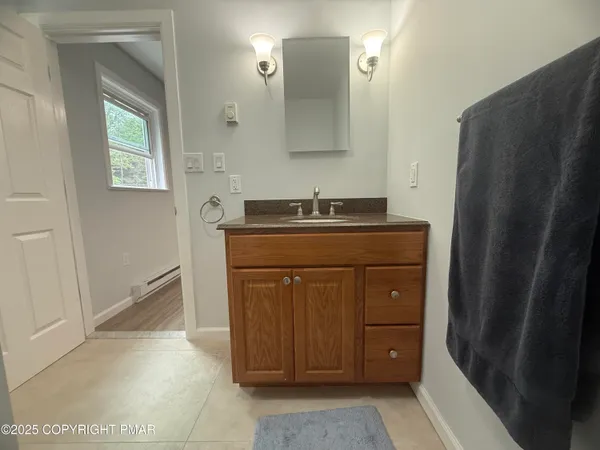 a bathroom with a granite countertop sink and a mirror