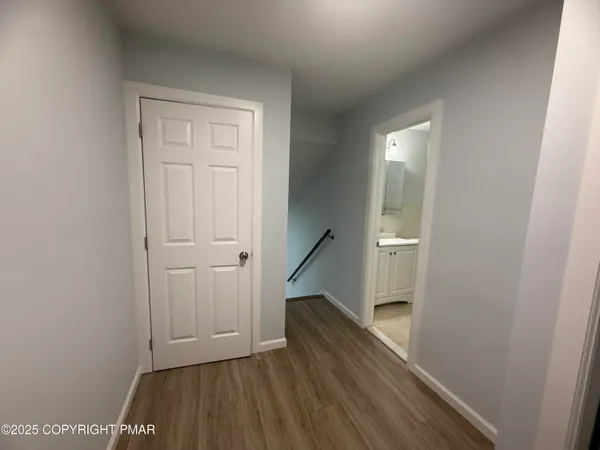 a view of a hallway with wooden floor and staircase
