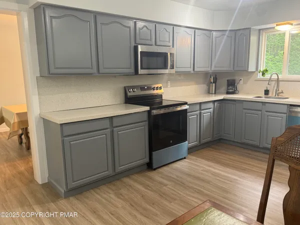 a kitchen with cabinets appliances and a window