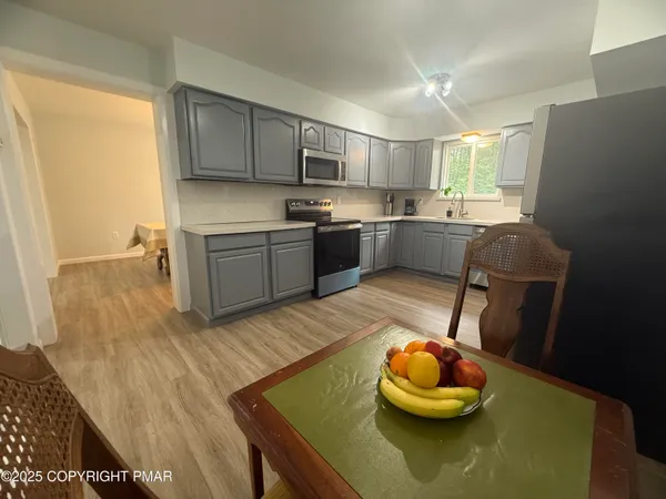 a kitchen with stainless steel appliances granite countertop a sink dishwasher a stove a refrigerator with wooden cabinets and floor