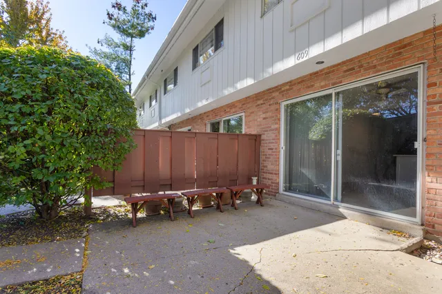 a view of a patio with table and chairs with wooden floor and fence