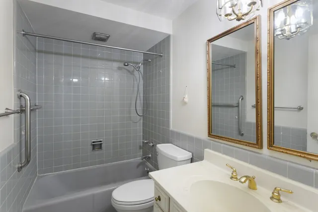 a bathroom with a bathtub shower sink vanity and toilet