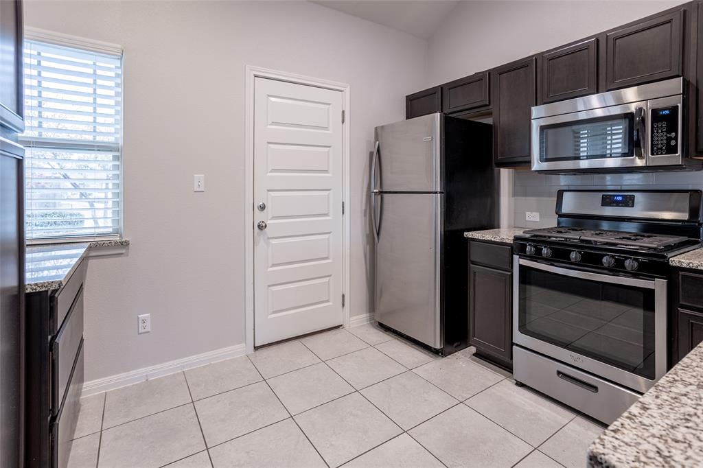 615 Stampede Road San Marcos, TX 78666 - Photo 21 of 26 Modern kitchen with granite countertops and stainless steel appliances.