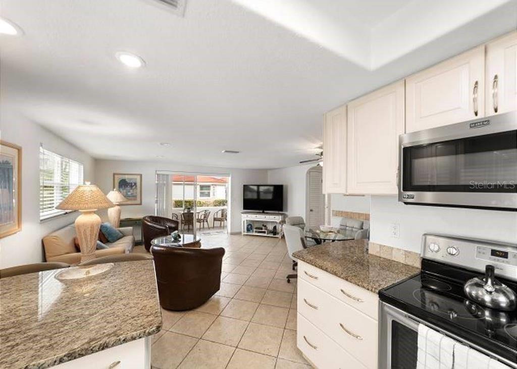 6154 Midnight Pass Road, Unit D18 Sarasota, FL 34242 - Photo 2 of 10 a kitchen with a stove a sink a microwave and cabinets