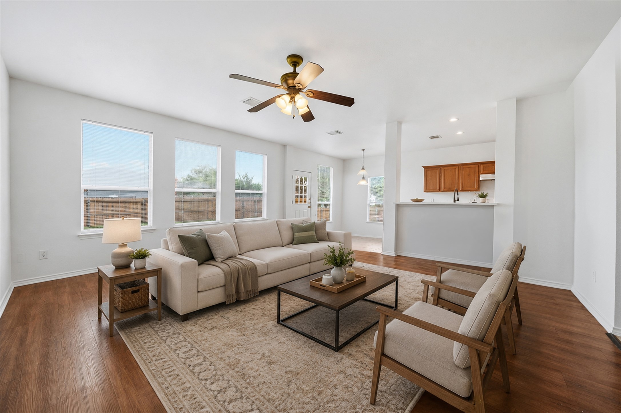 118 Invierno Street Kyle, TX 78640 - Photo 5 of 37 Well-lit living area with hardwood floors opens to a contemporary kitchen, perfect for entertaining.