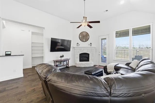 a living room with furniture a flat screen tv and a fireplace