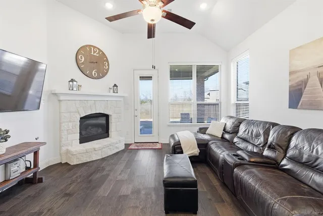 a living room with furniture a large window and a fireplace