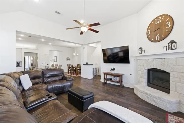 a living room with furniture a flat screen tv and a fireplace