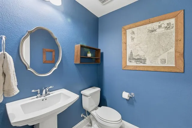 a bathroom with a toilet a sink and mirror