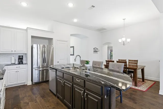 a kitchen with a sink appliances and cabinets