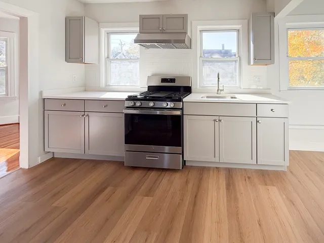 a kitchen with granite countertop a stove and a sink