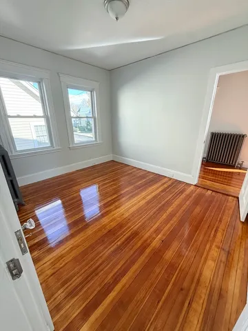 a view of a room with wooden floor and window