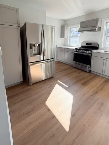 a kitchen with stainless steel appliances granite countertop a refrigerator a stove a sink and a microwave