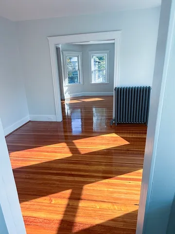 a view of a room with wooden floor and window