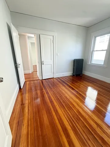 a view of empty room with wooden floor and front door