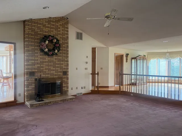 a view of empty room with fireplace and fan