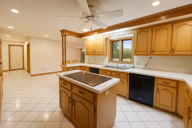 a kitchen with a sink a stove top oven and cabinetry