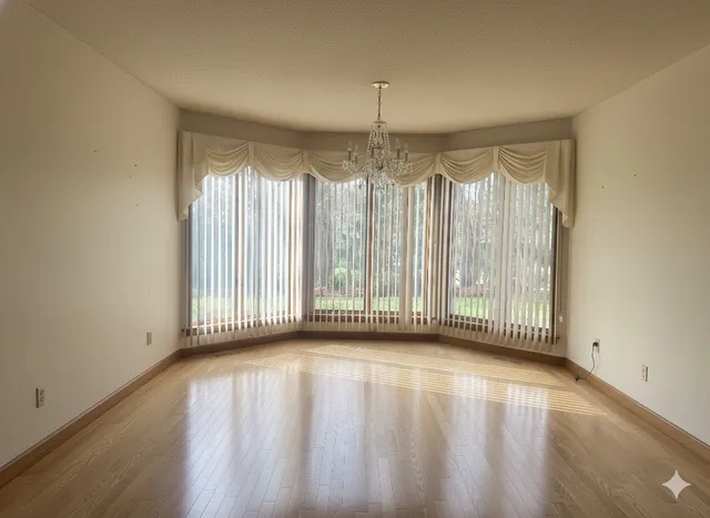 a view of a room with wooden floor and a window