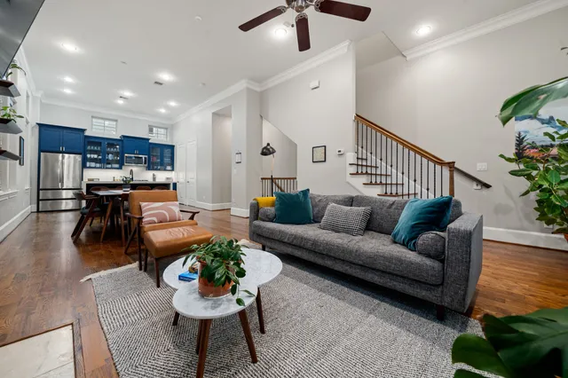 a living room with furniture kitchen view and a table