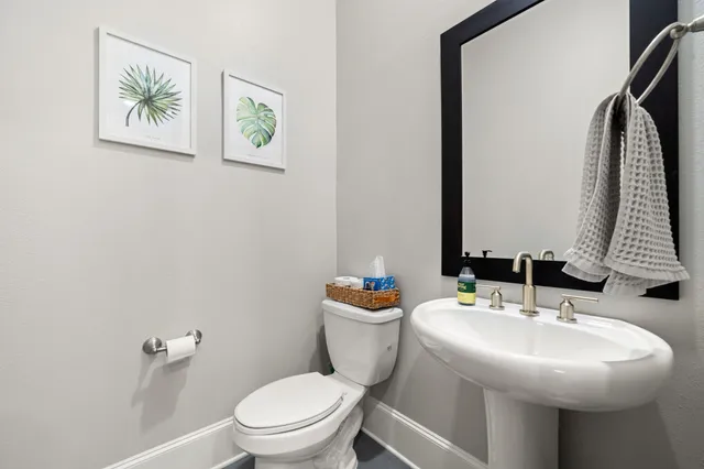 a bathroom with a sink a toilet and a mirror