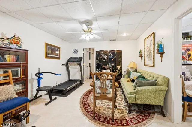 a living room with furniture gym equipment and a chandelier
