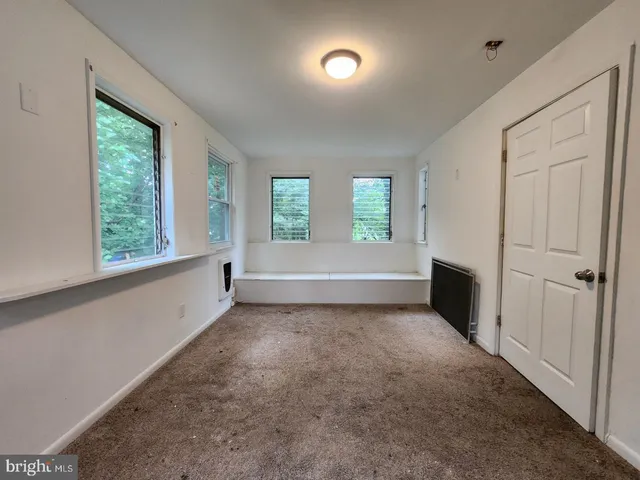 an empty room with windows and closet