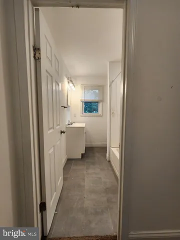 a view of a hallway with bathroom and a sink