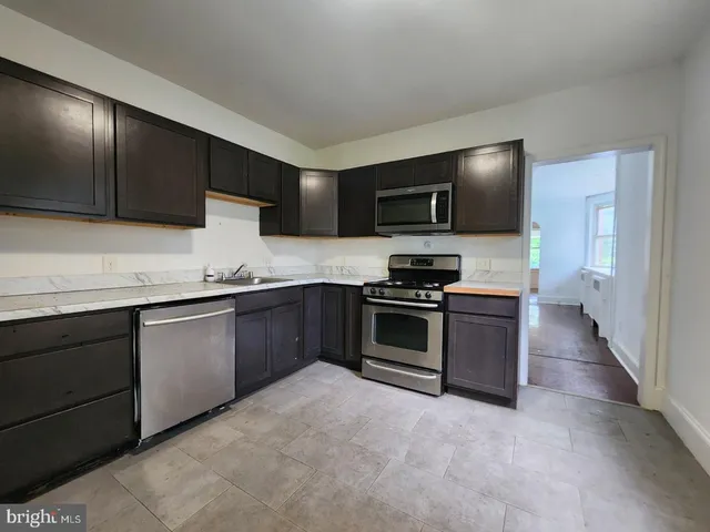 a kitchen with granite countertop a sink and steel appliances