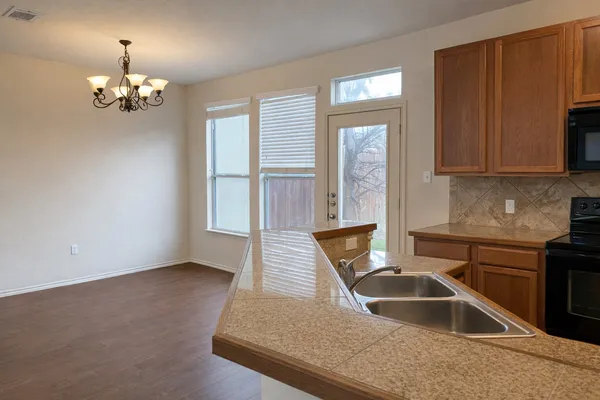 a view of kitchen with granite countertop stainless steel appliances a sink dishwasher a refrigerator microwave and stove