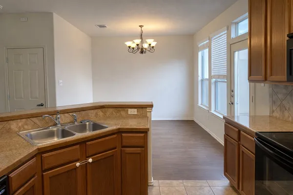 a view of a kitchen with a sink dishwasher a stove and dishwasher with wooden floor