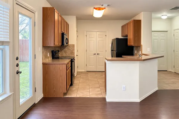 a kitchen with cabinets and wooden floor