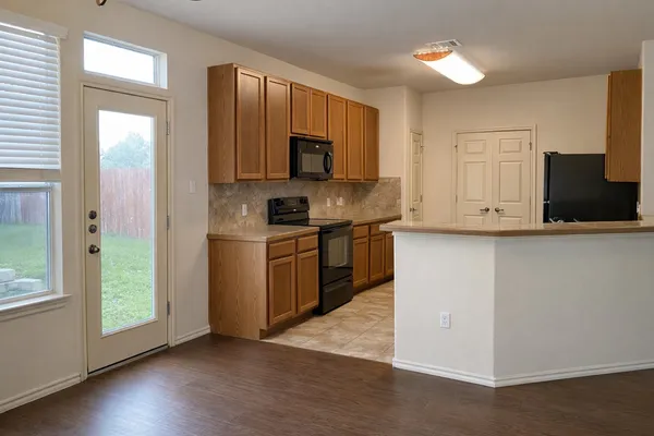 a kitchen with stainless steel appliances granite countertop a stove a sink and a refrigerator