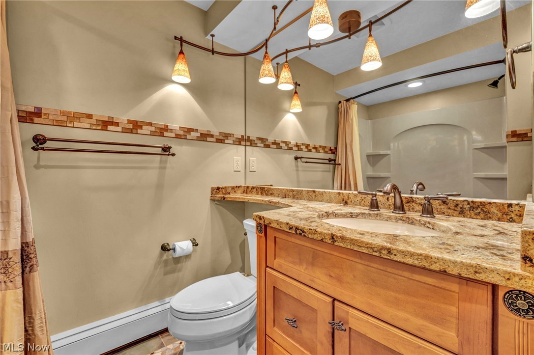 6845 Liberty Road Solon, OH 44139 - Photo 33 of 47 Bathroom vanity featuring a light wood-finish cabinet with decorative hardware, a built-in sink, and a speckled countertop